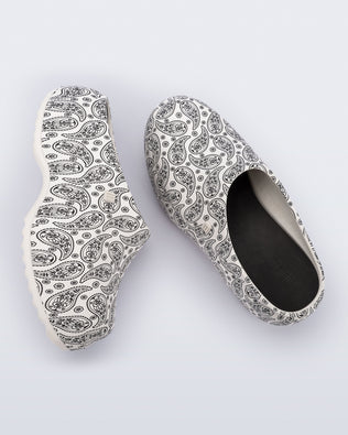 Side and top view of a pair of white print Free Clog Print platforms with black paisley print