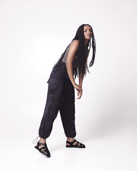 Model in black pants and grey shirt wearing a pair of black Emma women's sandals.