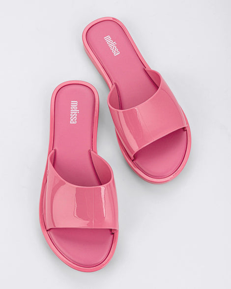 A top view of a pair of pink tortoiseshell Melissa Miranda slides