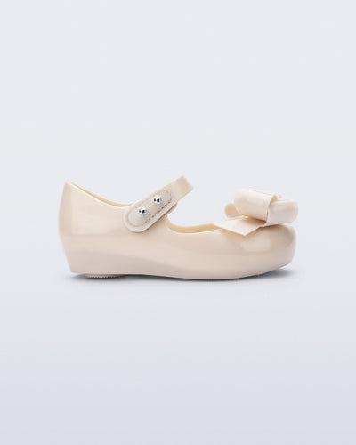 Side view of a beige Ultragirl Classy baby ballerina with beige bow.