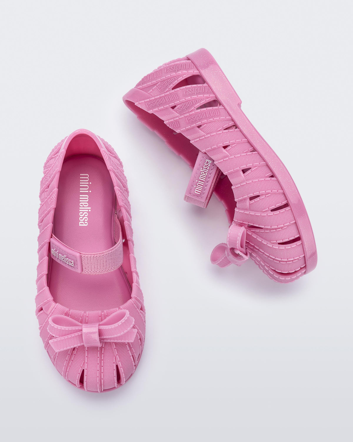 Top and side view of a pair of glitter pink M Lover Ballerina baby flat with bow and strap