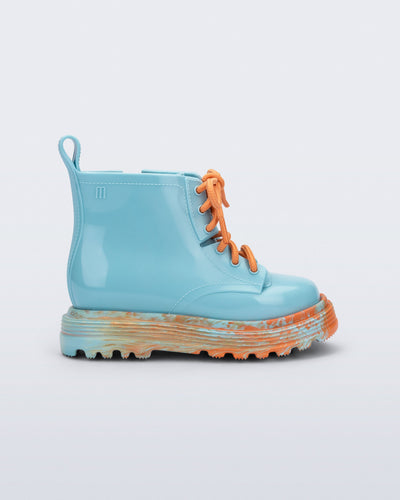 Side view of a blue Coturno baby boot with orange laces.