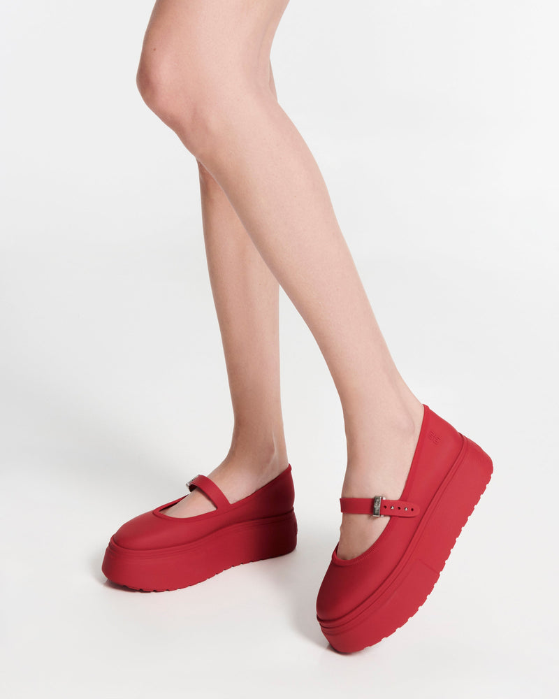 Model's lets in a pair of red Soft Ballerina Platform flats