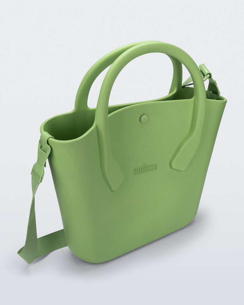 Angled view of a green Free Big Bag with handles and a strap