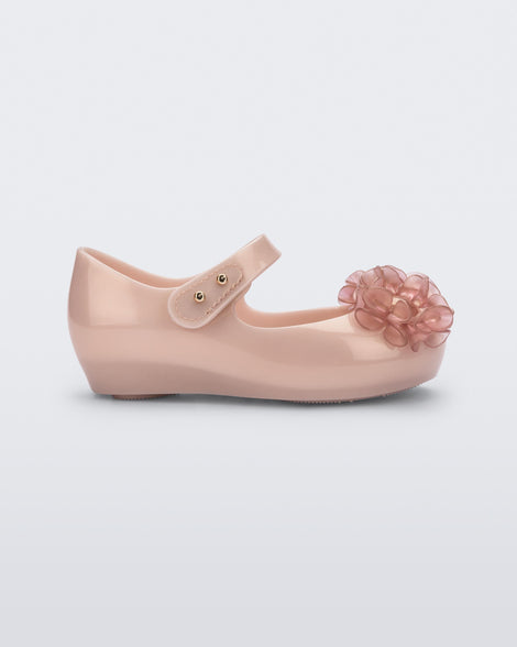 Side view of a pearly pink Ultragirl Springtime baby flat with two clear pink flowers and peep toe.