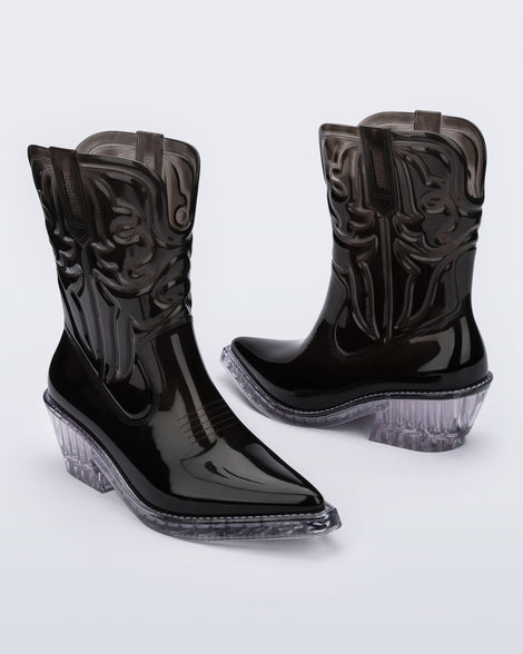 Angled view of a pair of black Texas boots with pointed toe and clear sole.