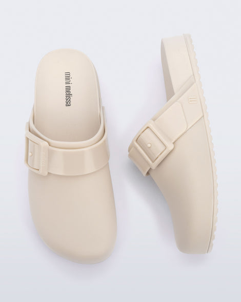 Top and side view of a pair of beige kids Cozy Clogs