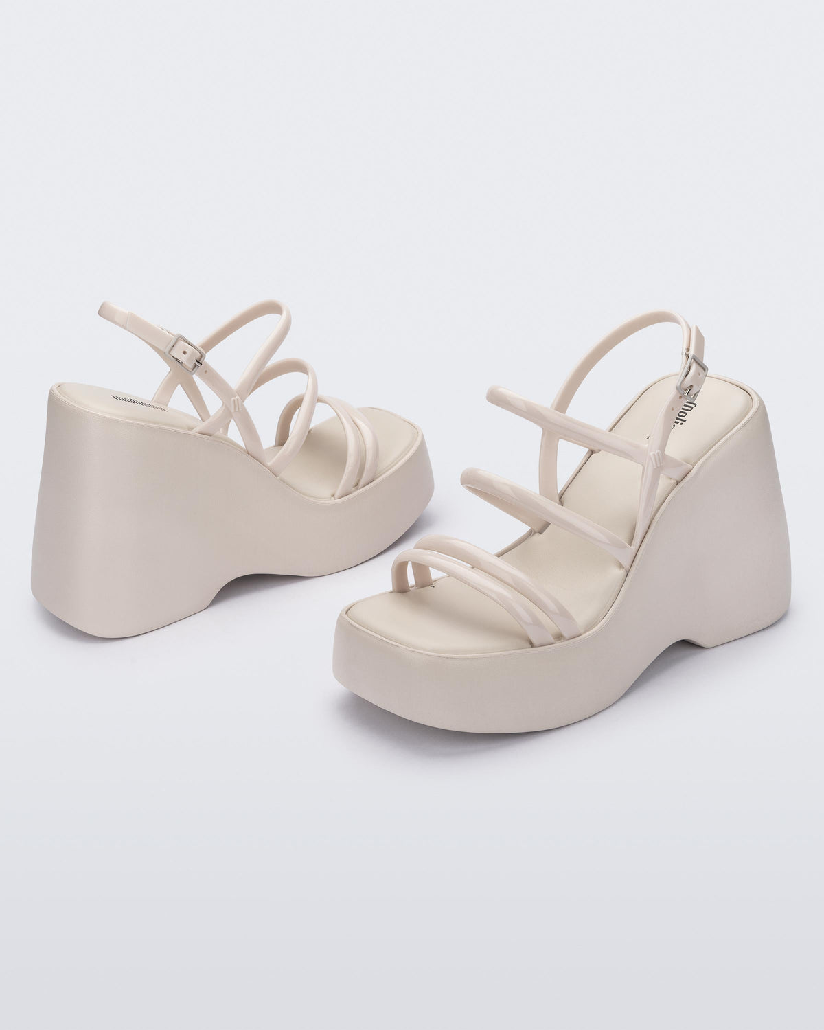 Angled view of a pair of white Jessie platform wedge sandals with side buckle ankle strap