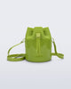 Side view of a Melissa Station bucket bag in Green. The bag has an adjustable shoulder strap and a drawstring top closure. The Melissa logo is on the bottom center of the front of the bag. 