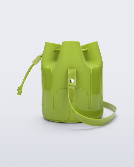 Side view of a Melissa Station bucket bag in Green. The bag has an adjustable shoulder strap and a drawstring top closure. 