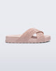 Side view of the Melissa Cozy slide sandals. The slide has two cross straps with Melissa logo embossed onto the straps. The color of the shoe is light pink. 