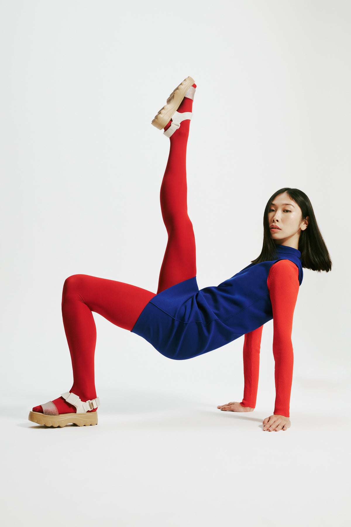 Model in a red and blue dress and red tights wearing a pair of beige/glitter Kick Off Sandals