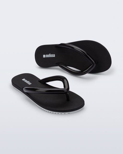 Top and angled view of a pair of black Flip Flop Airflow sandals with white bottoms.