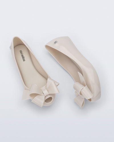 Top and side view of a pair of beige Ultragirl Classy kids ballerina flats with beige bow
