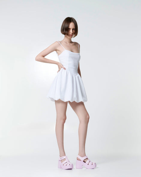 Model in a white shirt wearing a pair of pink Lulu platform heel fisherman sandals