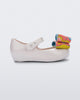 Side view of a white with multi-color patterned bow Ultragirl Wonderland baby flat