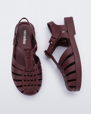 Top and side angled view of a pair of matte burgundy Possession kids fisherman sandals.