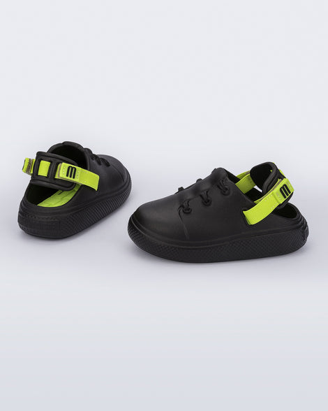 Side and back view of a pair of black with green back strap Charlie baby sneakers