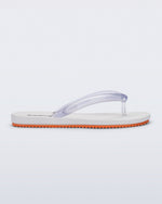 Side view of a white Flip Flop Airflow sandal with a clear strap and orange bottom