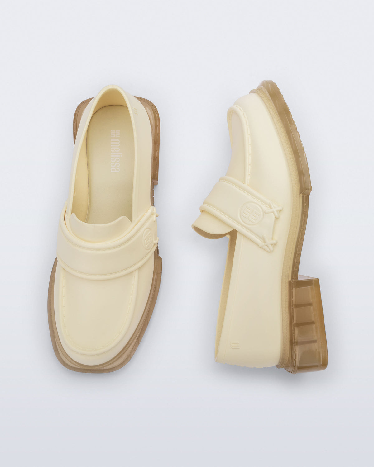 Top and side view of a pair of beige Spencer loafers with clear beige soles