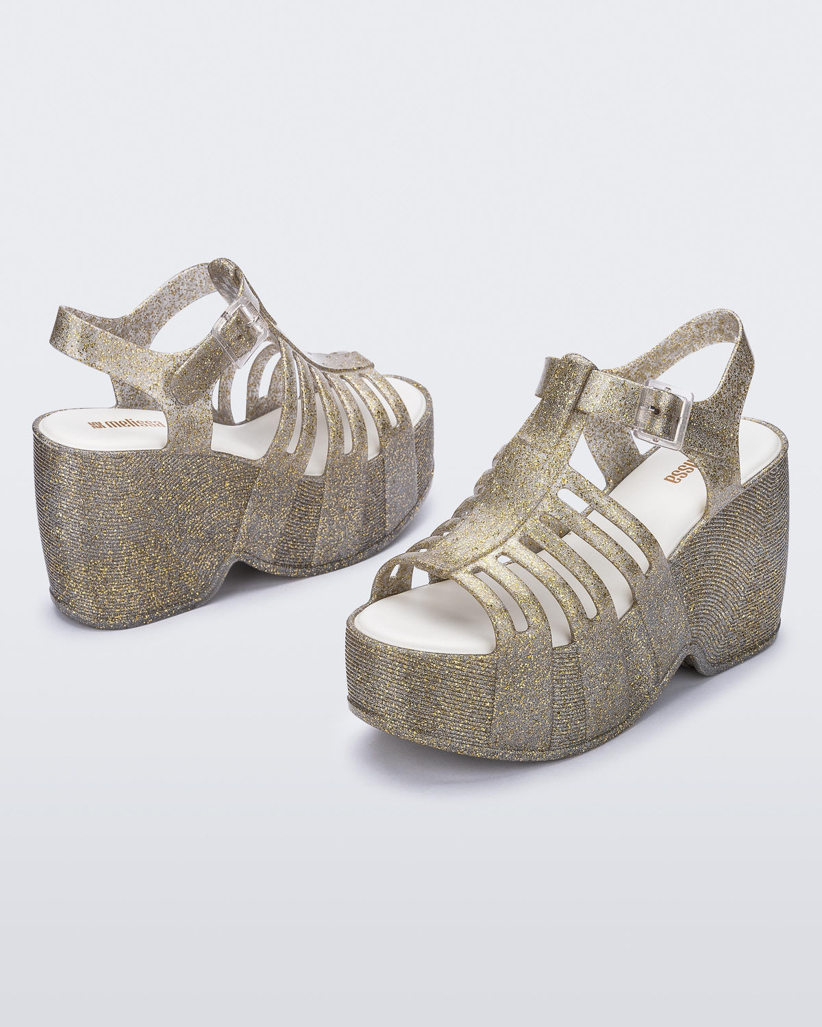 Back and side angled view of a pair of glitter gold Station 79 platform heels with ankle straps