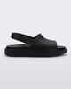 Side view of a matte black Mini Melissa Cloud sandal with a black insole, base and back velcro strap.