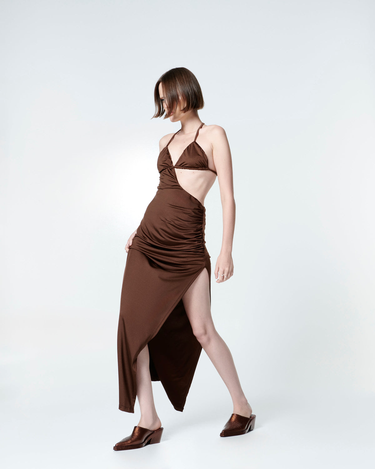 Model in a brown dress wearing a pair of bronze glitter Texas Mule heels