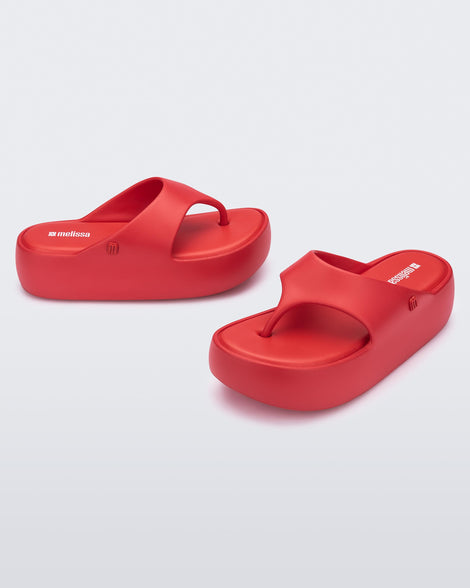 Side and angled view of a pair of red Free Platform Thong sandal
