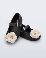 Angled view of a pair of black Soft Ballerina baby flats with beige flowers