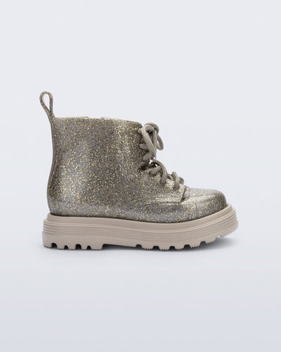 Side view of a beige/golden glitter Coturno lace up baby boot
