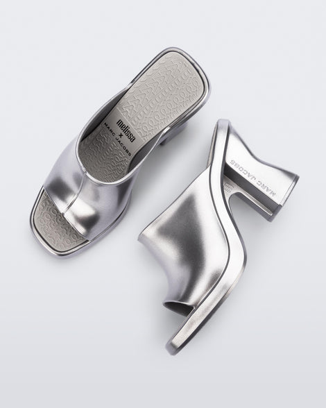 Top and side view of a pair of silver Mule + Marc Jacobs heels.