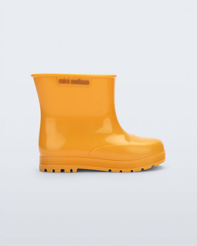 Side view of an orange Welly baby rainboot