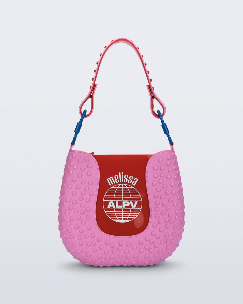 Front view of a pink Nina Bag + Alexandre Pavao shoulder bag with red accents