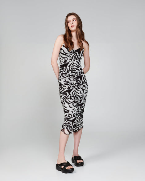 Model in a black and white dress wearing a pair of black Free Rise platform slides