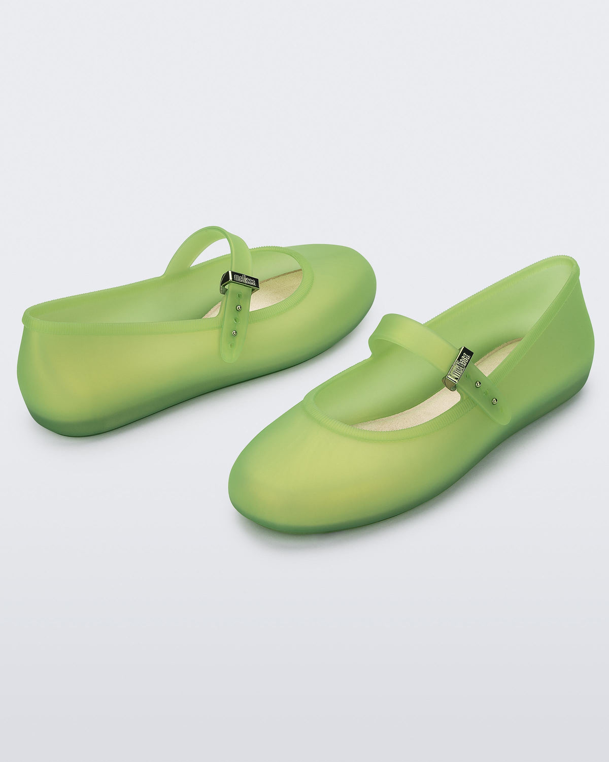 Angled view of a pair of green Soft adult flats with strap and green buckle