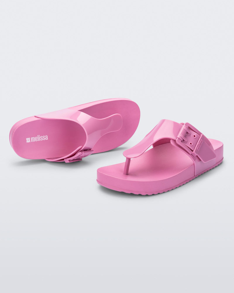 Top and angled view of a pair of pink Cozy Flip flops