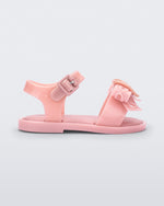 Side view of a glitter pink Mini Melissa Mar Sandal Heart sandal with a glitter pink heart bow detail on the front strap and an ankle strap