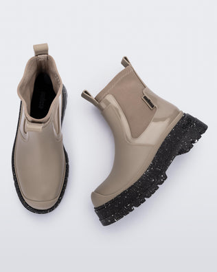 Side and top view of a pair of beige Drip Boots with black sole