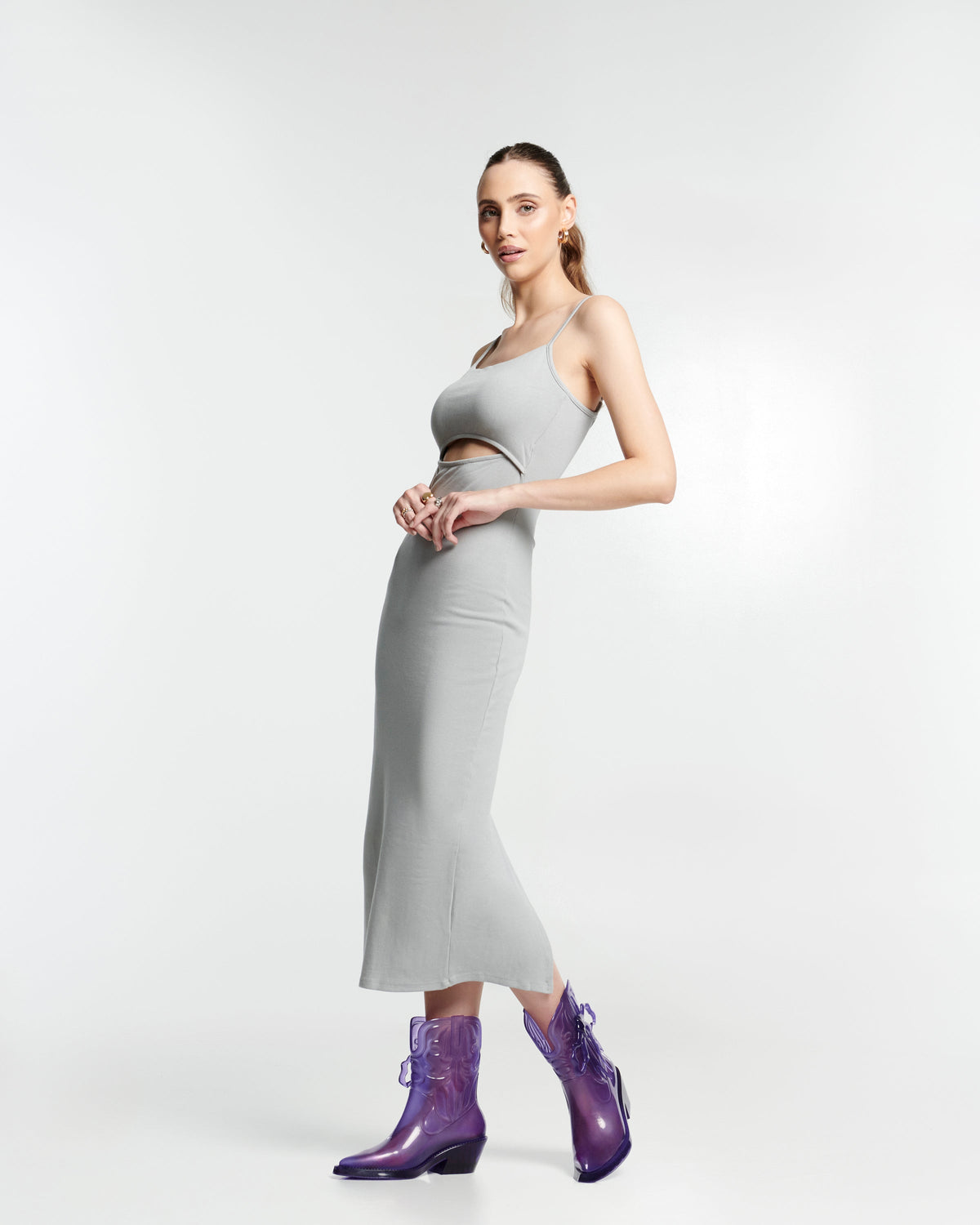 Model in a grey outfit wearing a pair of transparent purple Texas + Maldito boots