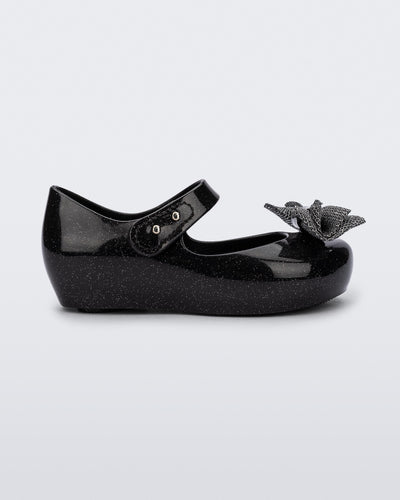 Side view of a black glitter Ultragirl Sweet baby ballerina flat with bow