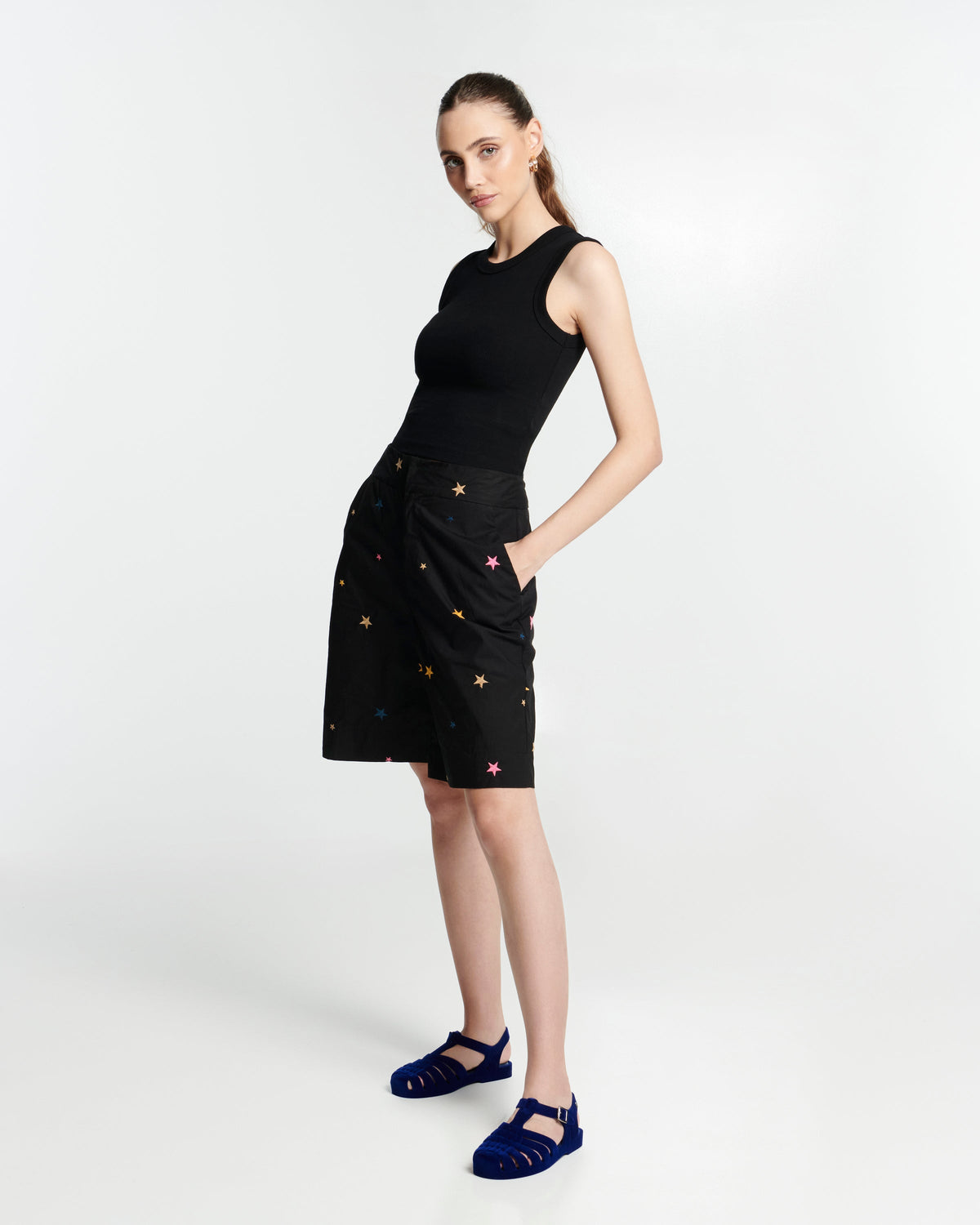 Model in a black dress wearing a pair of flocked blue Possession Velvet fisherman sandals