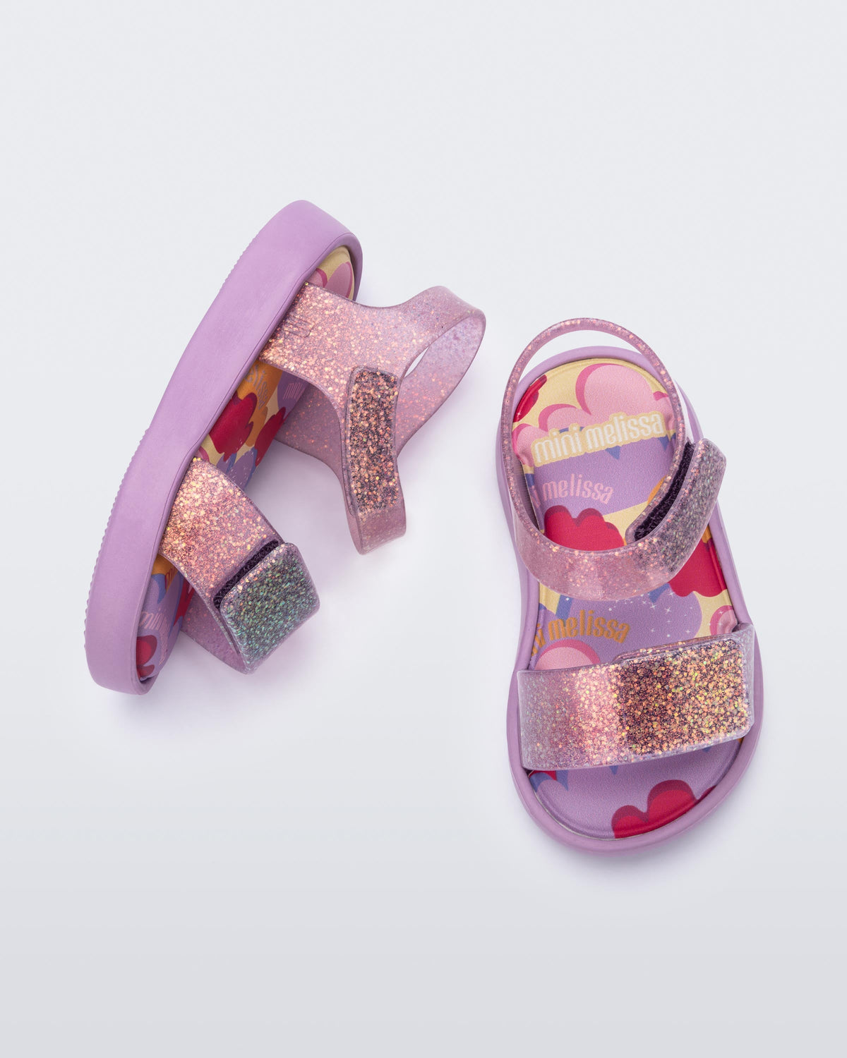 Top and side view of a pair of glitter lilac baby Jump sandals