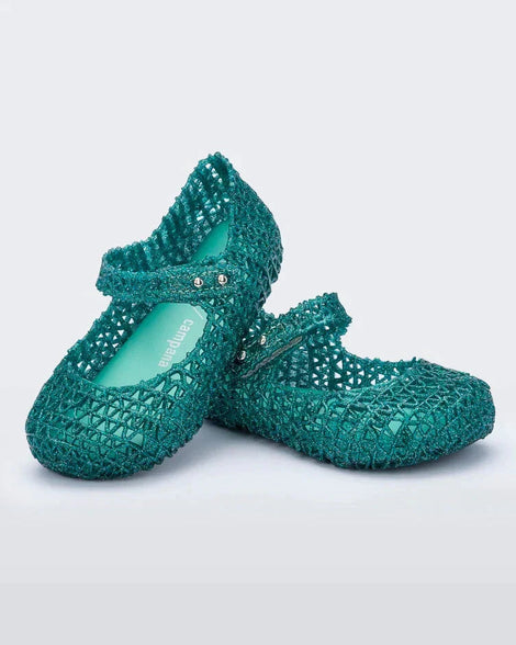 Angled view of a pair of Mini Melissa Campana flats for baby in green glitter with an open woven texture.