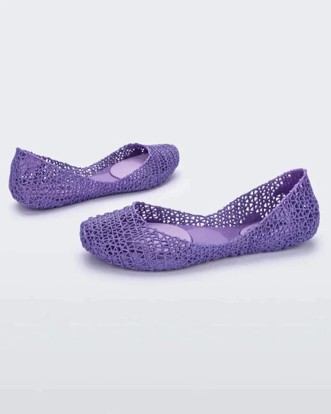 Angled view of a pair of Melissa Campana flats in lilac with an open woven texture. 