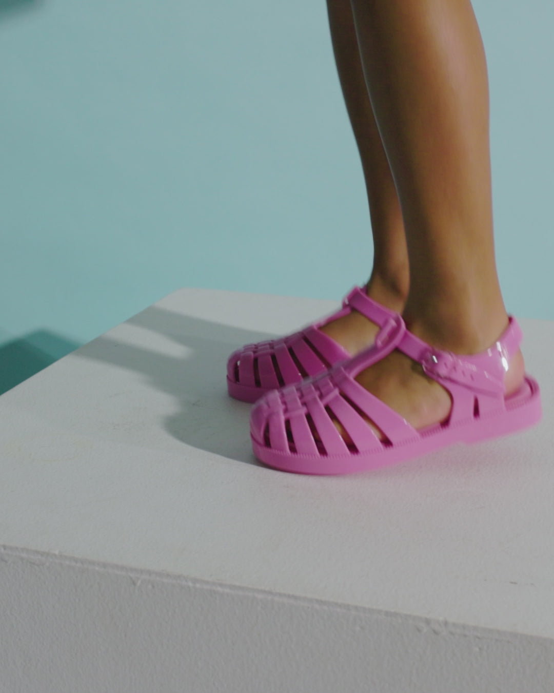 Video with no sound of a child's legs wearing a pair of pink Possession fisherman kids sandals.