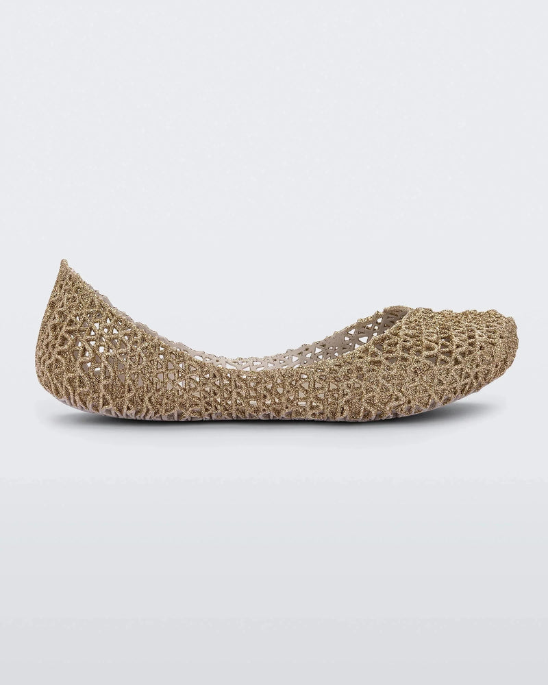 Side view of a white / gold glitter Mini Melissa Campana flat with an open woven texture.