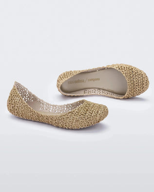 A side and top view of a pair of white / gold glitter Mini Melissa Campana flats with an open woven texture.